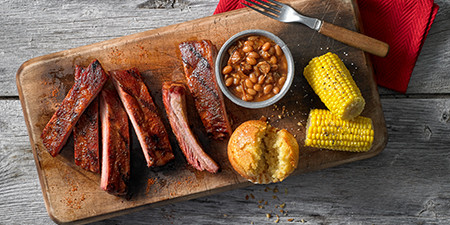 Award-winning ribs with baked beans, bread and corn